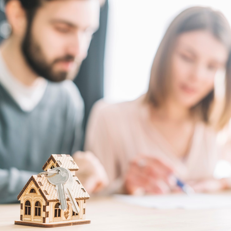 toy-house-keys-near-blurred-couple
